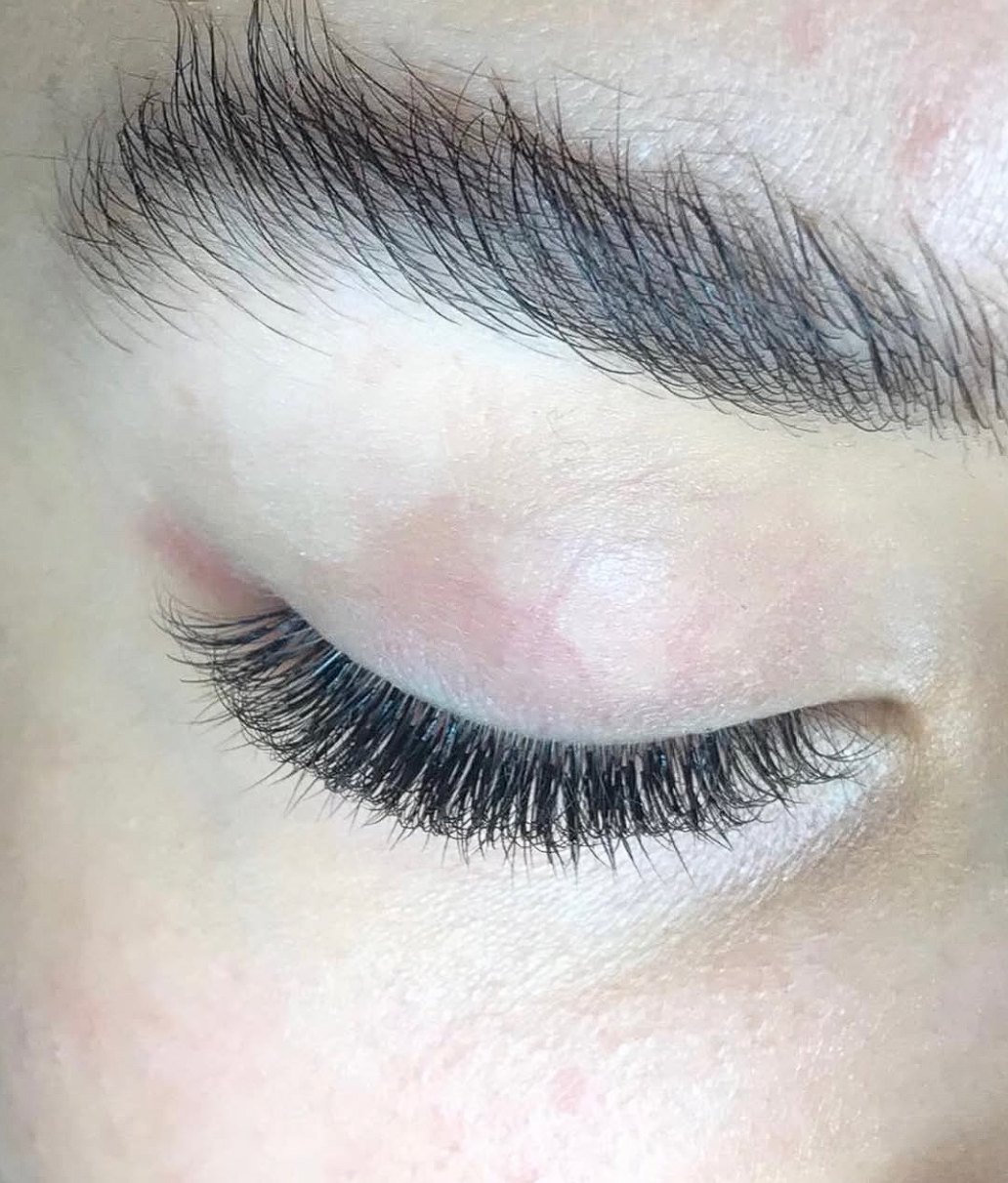 Close-up of a full set of lash extensions on a closed eye