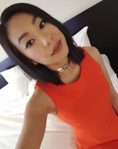 Client in an orange dress showing her lash extensions